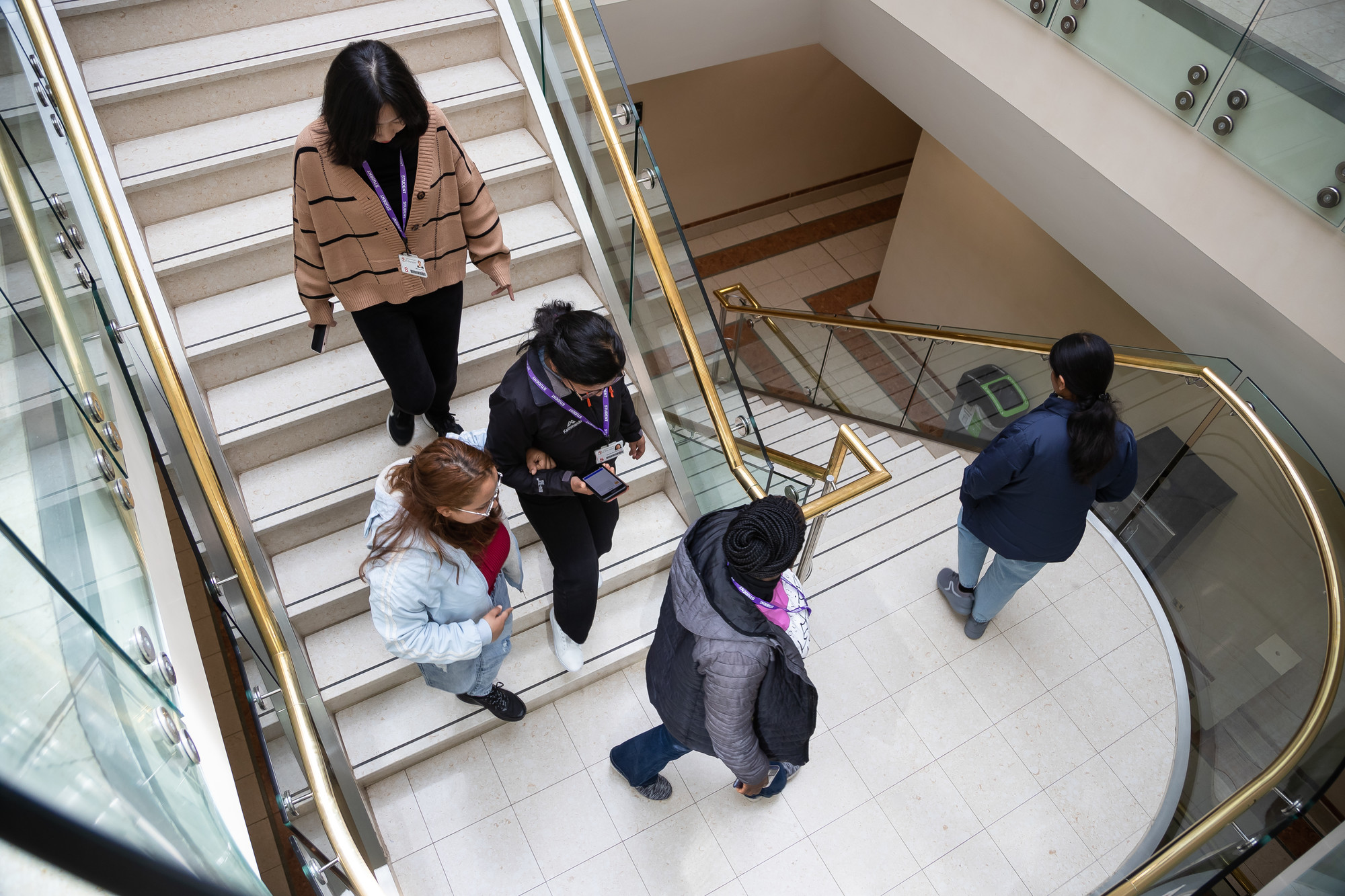 Group of students walking down the stairs at Queen's Park