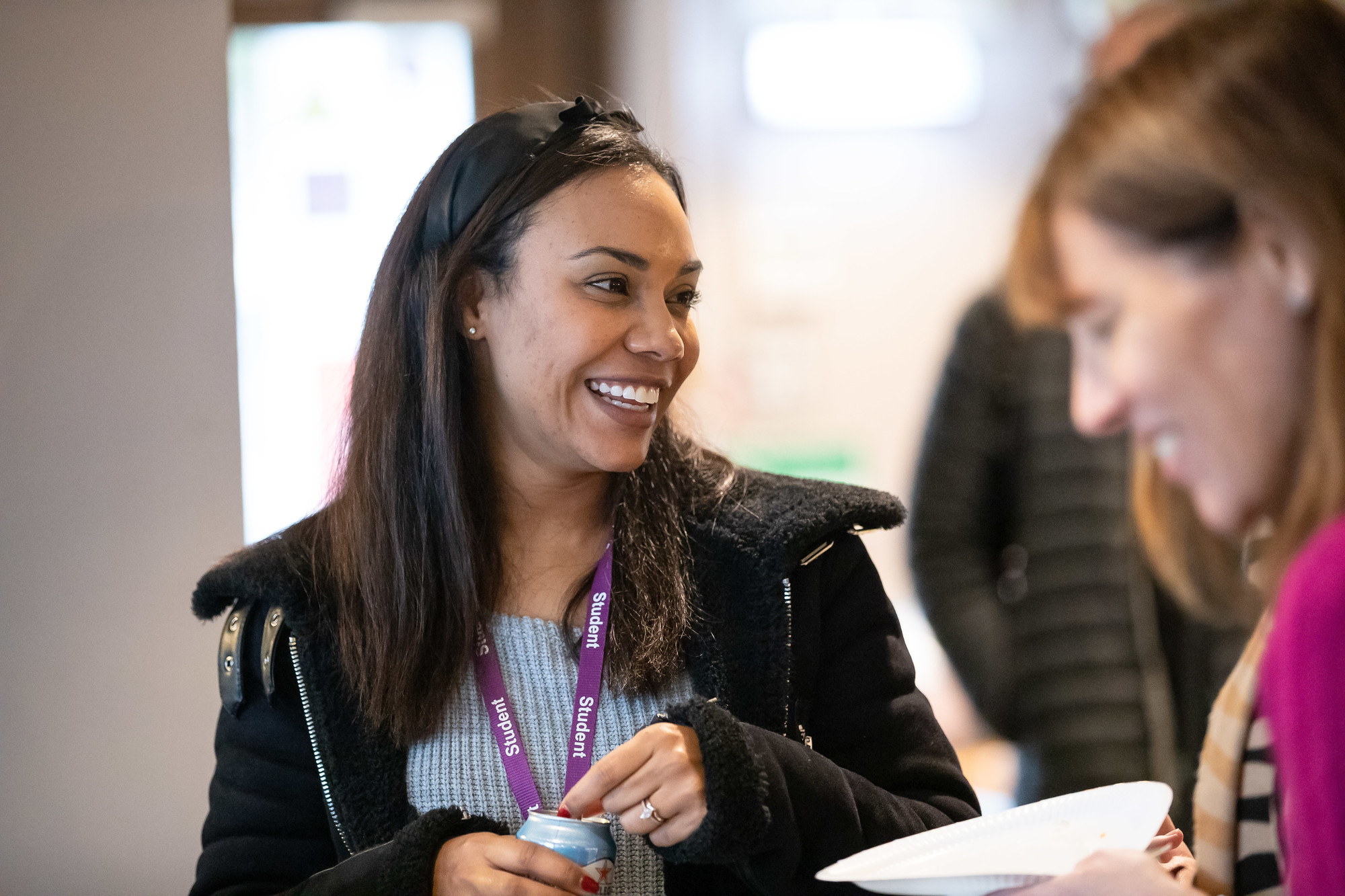 Smiling student opening a soft drink